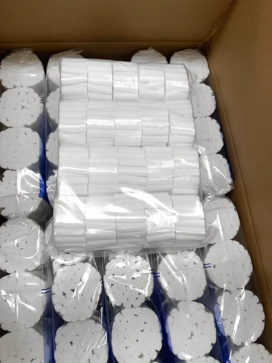 Clear bags of dental cotton roll bundles in an open export carton