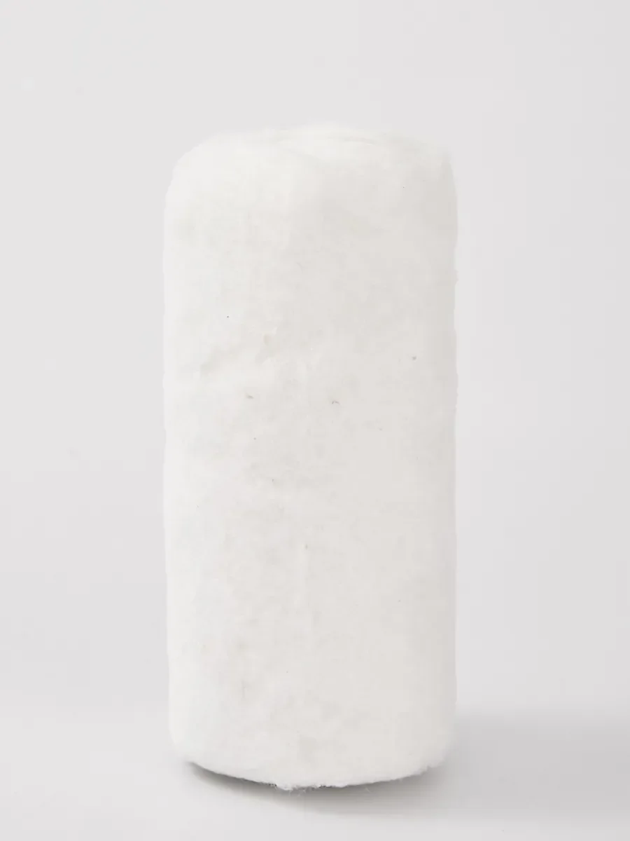 Absorbent cotton roll before wrapping, standing on a grey studio background